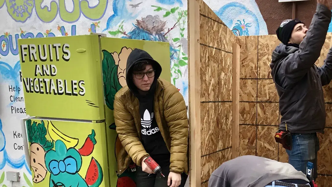 Volunteers building a fridge shelter